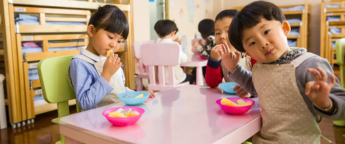 Small children having lunch at a colorful table