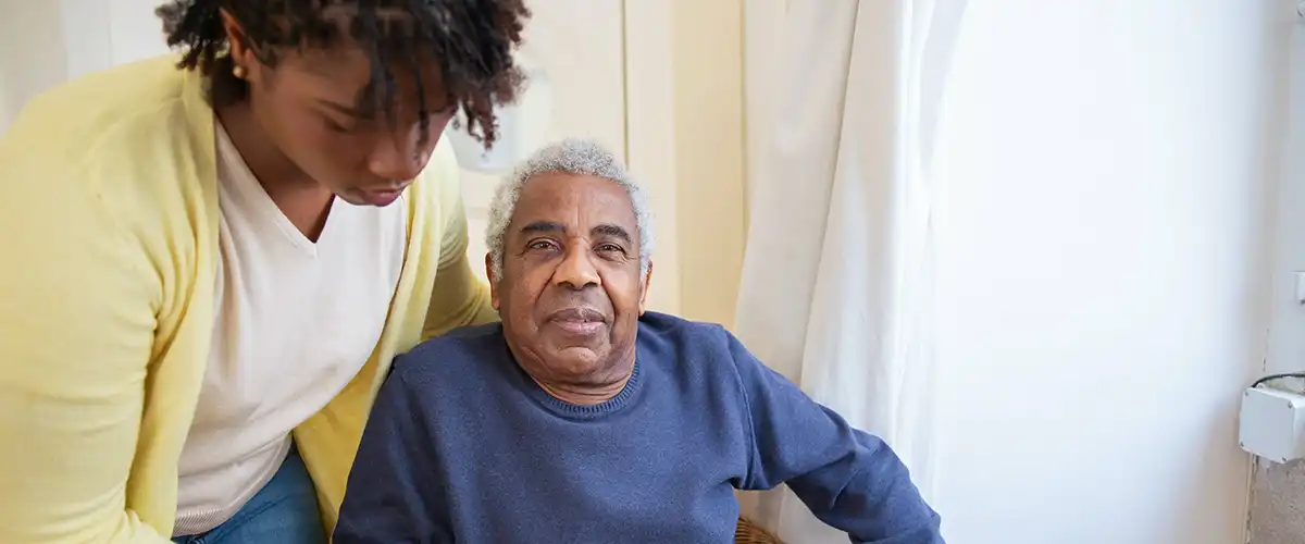 Younger woman helping an older man in a wheelchair