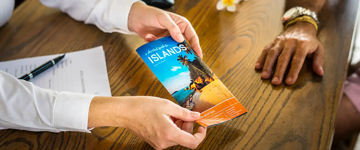 A travel salesman handing a client a brochure