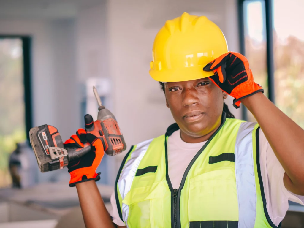 Woman in home construction with hard hat and power tools