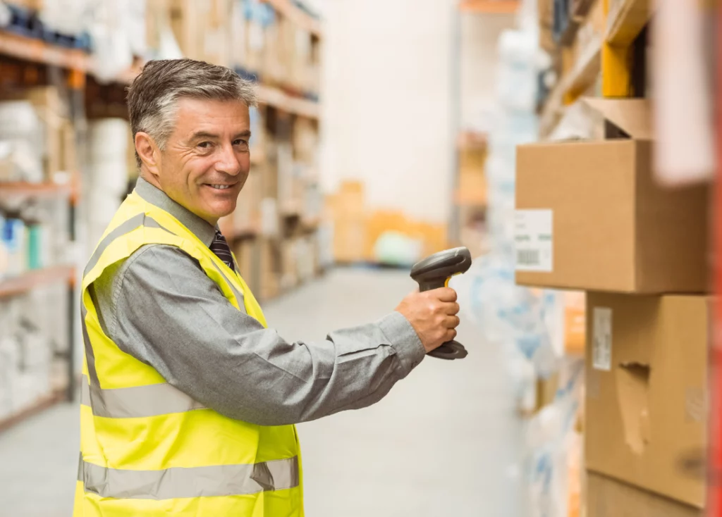 Man scanning barcodes on boxes to track incoming inventory.