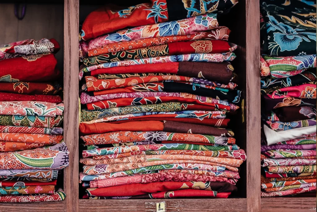 Inventory collection of shirts on a shelf, ready for sale.