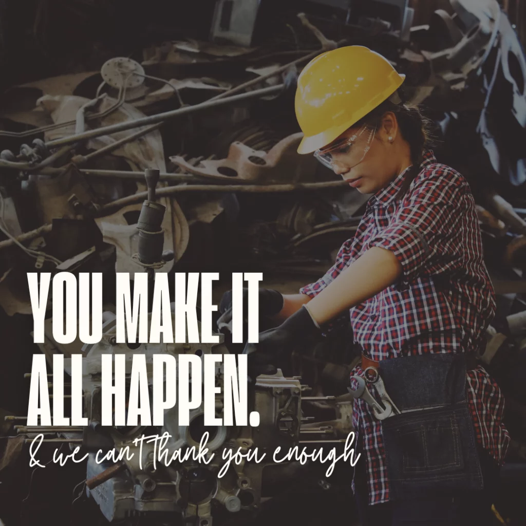 Background shows machinery. Woman wearing a yellow helmet, safety glasses, red and white plaid shirt shown working with tools while wearing black gloves. She also wears a denim waist apron that has a couple of wrenches and tools in the pocket. Text in white font is used to spell out the Labor Day quote: you make it happen & we can’t thank you enough.