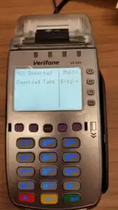 Verifone terminal on table dislaying VCS Download Type and two options for Multi or Single