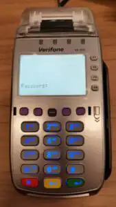 Verifone terminal on table displaying prompt for password